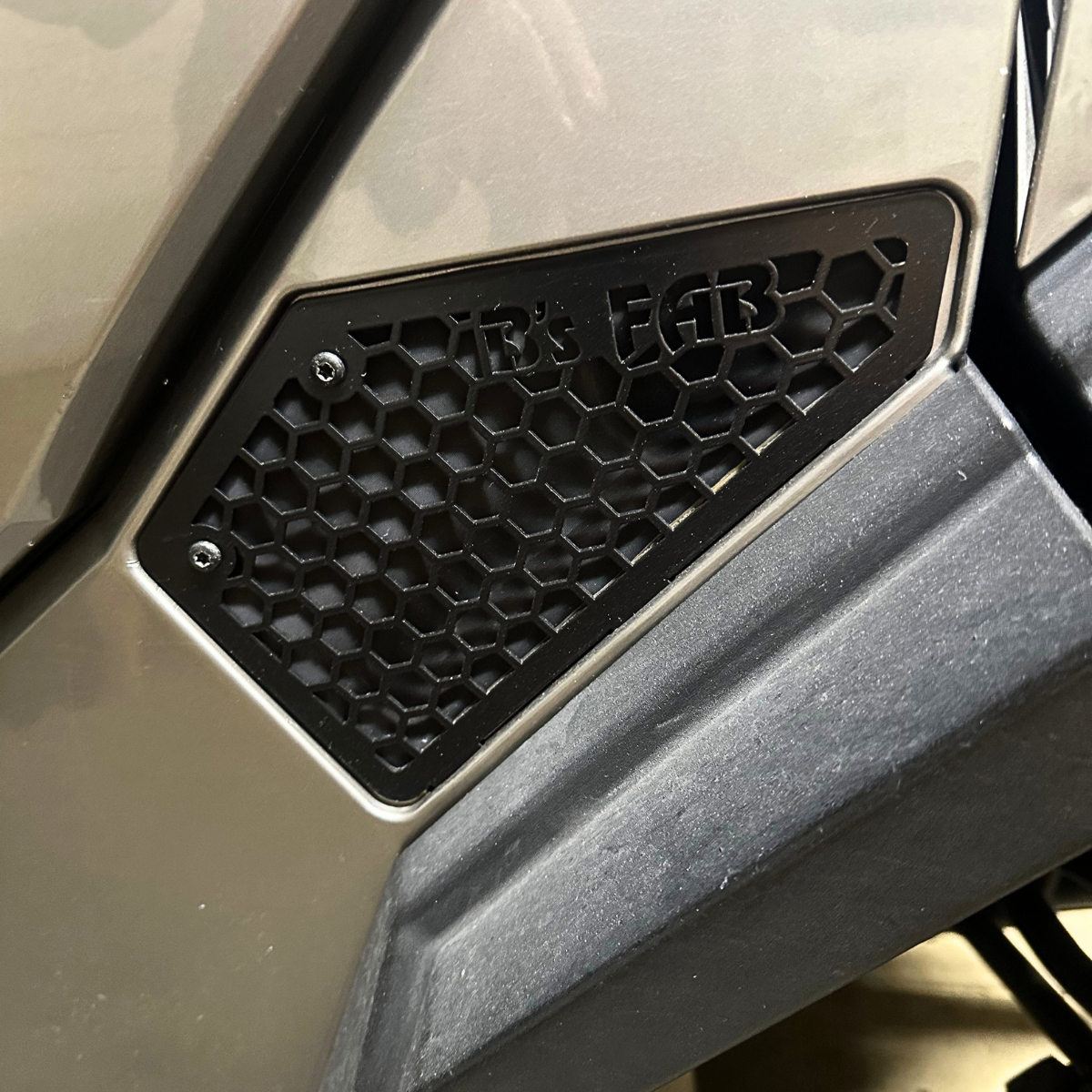 Black hexagonal mesh vent with R's FAB logo on vehicle