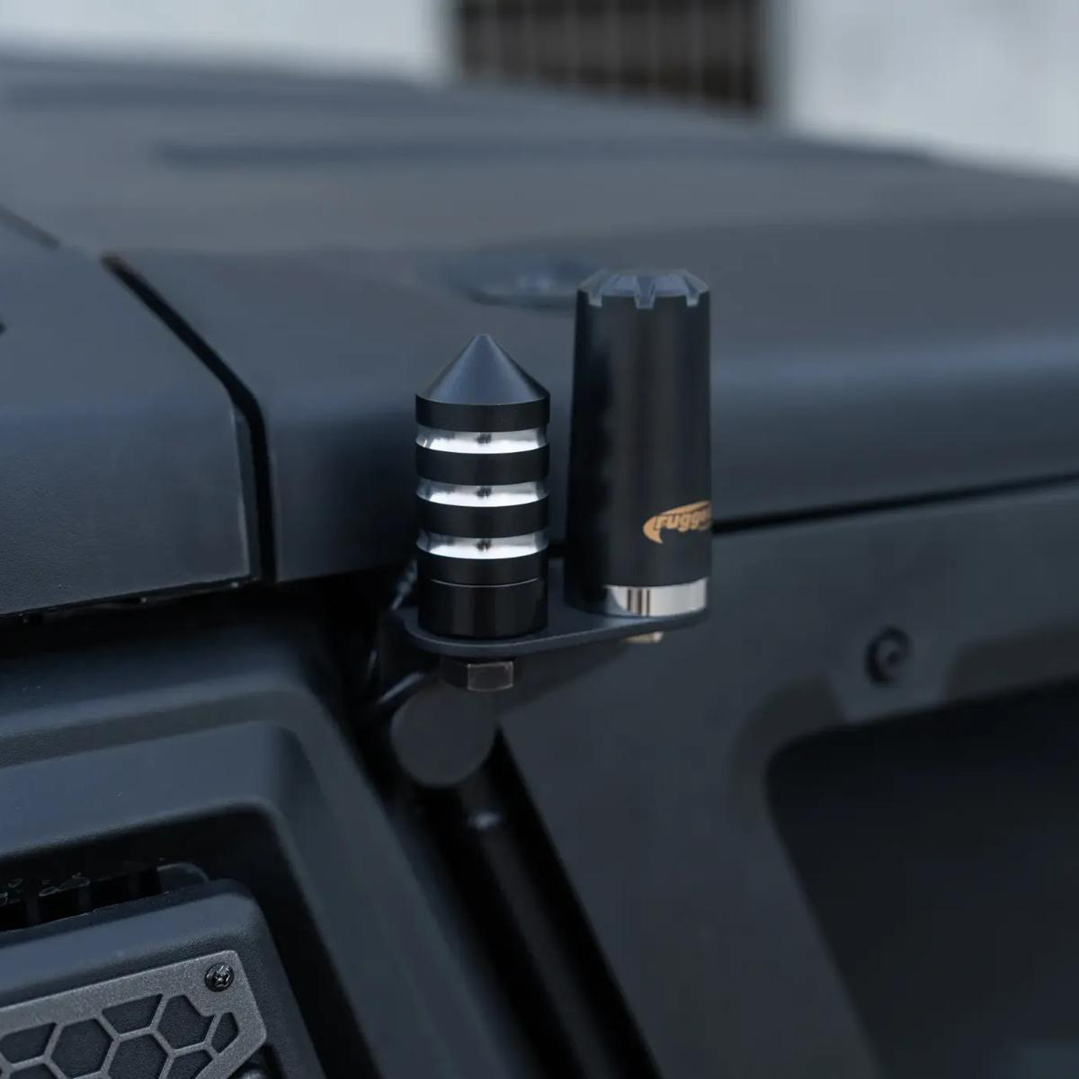 Black spike and cylindrical accessories mounted on a rugged vehicle.