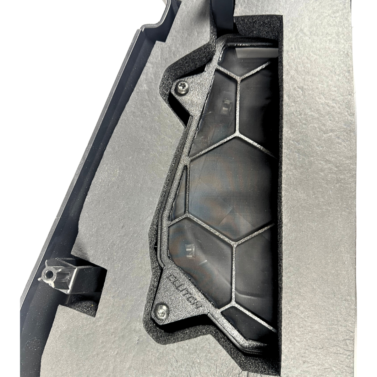 Black hexagonal grid device in dark foam packaging.